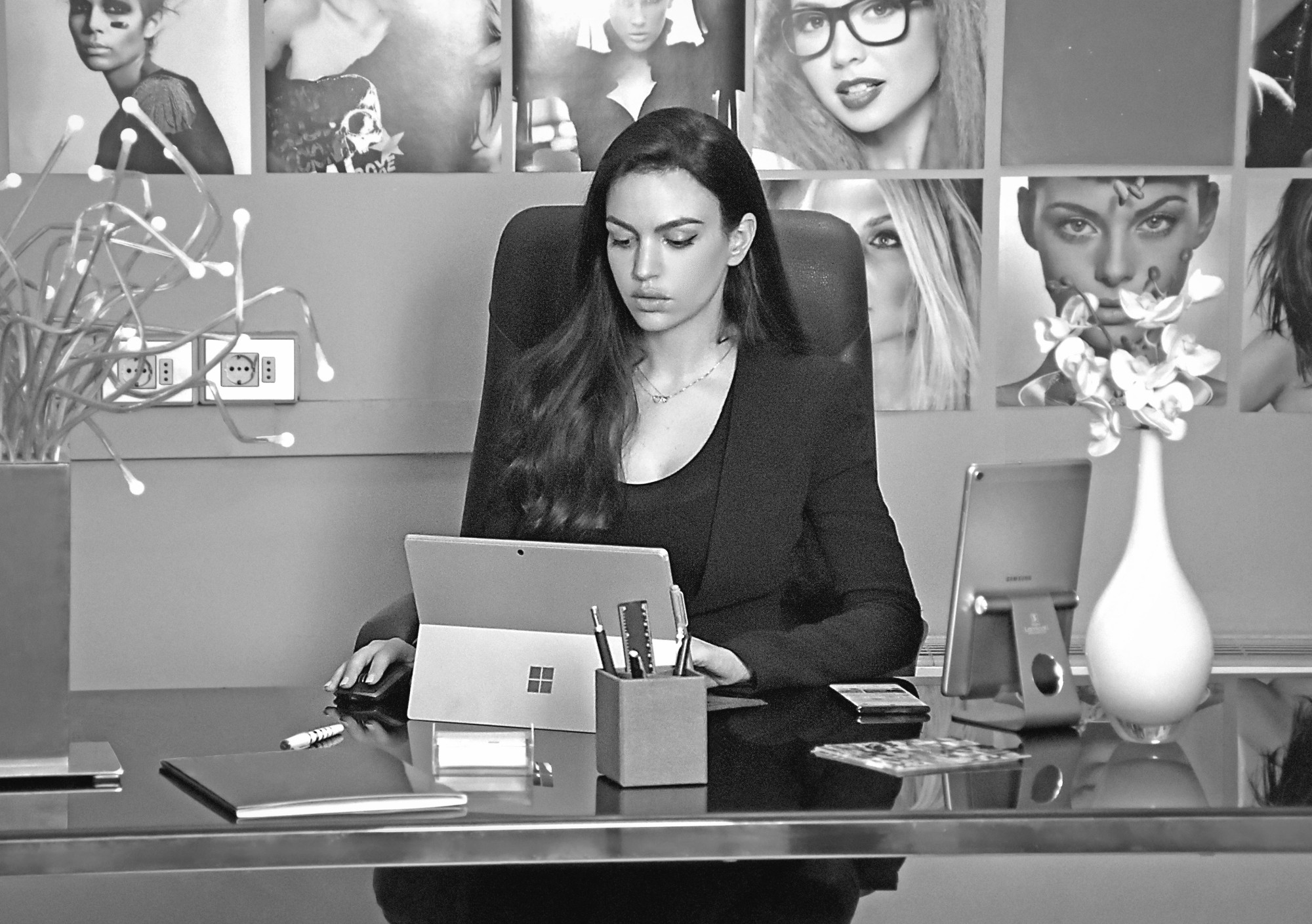 Eye On Model booker working at her desk surrounded by talent photos at the Milan headquarters