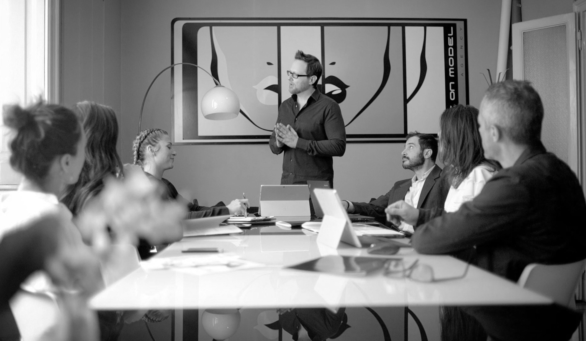 Eye On Model team meeting with booker presenting to colleagues around the conference table at the Milan headquarters